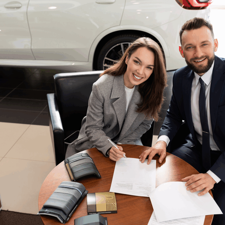 Customer signing vehicle purchase documents with salesman