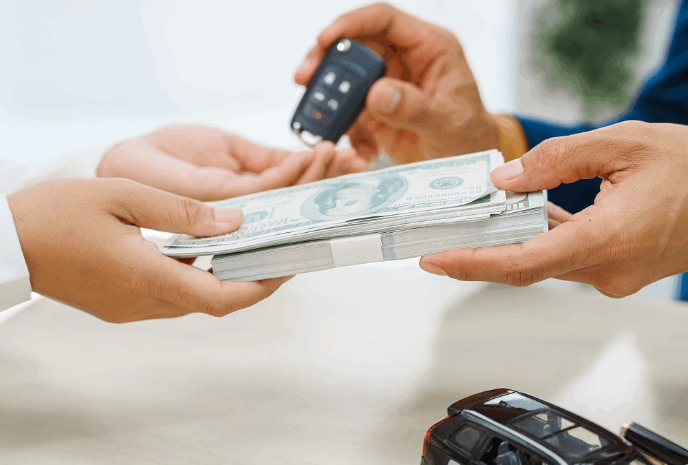 Hands counting money beside a miniature car