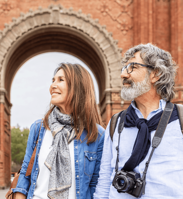Senior couple sightseeing in front of a historical brick arch